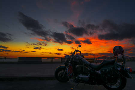 classic motorcycle by the sea at sunsetの写真素材