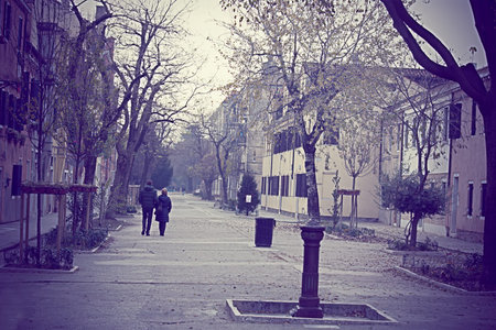 couple walking in a urban park in Venice, Italyの写真素材