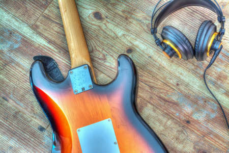 electric guitar and headphones on a wooden board. Processed for hdr tone mapping effectの写真素材