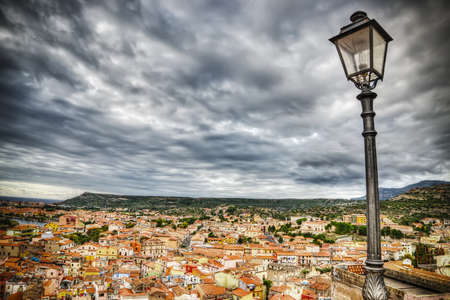 lamppost over Bosa buildings on a cloudy day. Processed for hdr tone mapping effectの写真素材