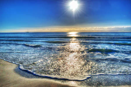 small waves by the shore on a sunny day. Processed for hdr tone mapping effectの写真素材