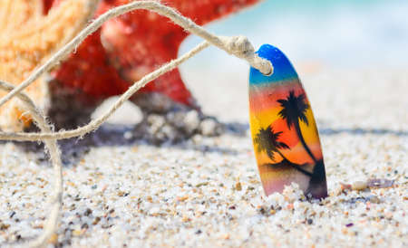 close up of a necklace and starfish stuck in the sandの写真素材