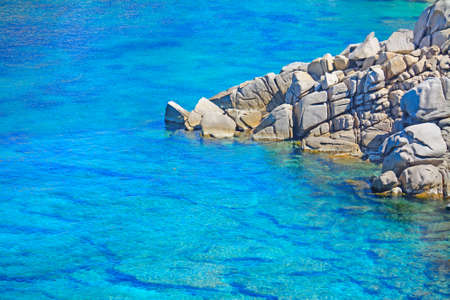 grey rocks on the blue water in Capo Testa, Sardiniaの写真素材