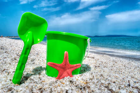 green bucket and spade by the sea in hdr tone mapping effectの写真素材
