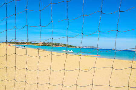 golden beach seen through a beach volley netの写真素材