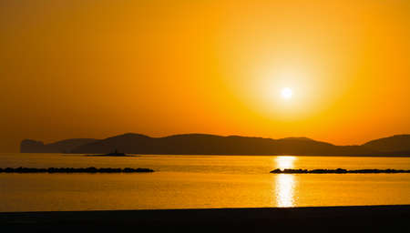 orange sunset in Alghero shoreline, Italyの写真素材