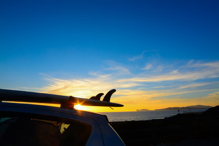 close up of a surfboard on a car roof at sunsetの写真素材