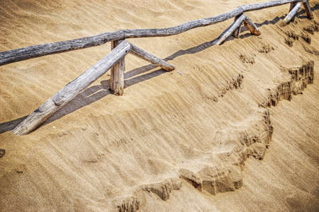 wooden palisades and golden sand in vintage tone effectの写真素材