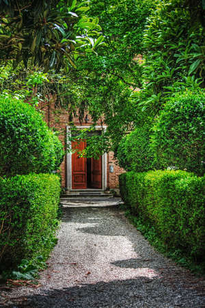 wooden door in a beautiful italian gardenの写真素材