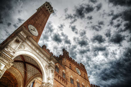 Torre del Mangia under a cloudy sky, Italyの写真素材