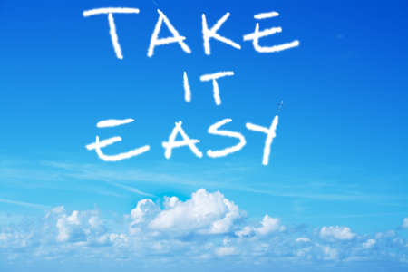 take it easy written in the sky with an airplane contrailの写真素材