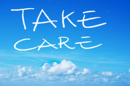 take care written in the sky with an airplane contrailの写真素材