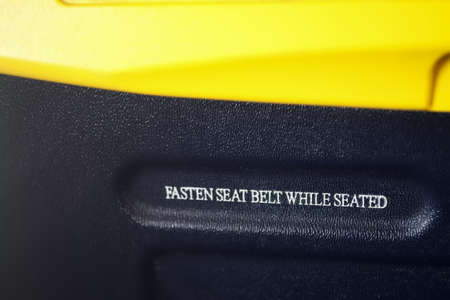 "fasten seat belt while seated" written on a passenger seatの写真素材