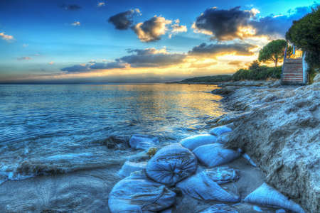 sand sacks on the shore at sunsetの写真素材