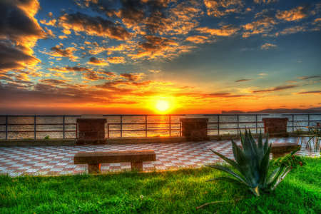 benches in Alghero seafront at sunset, Italyの写真素材