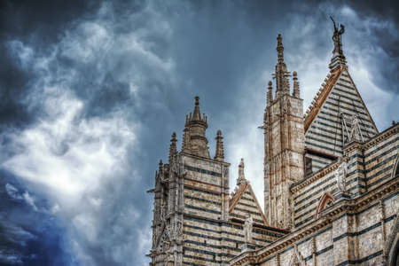 Siena Duomo under a dramatic sky seen from behind, Italyの写真素材