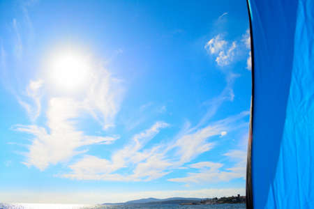 sunny sky seen from a blue tent on the beachの写真素材