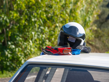 driver helmet and gloves on a car rooftopの写真素材