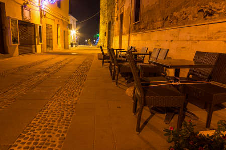 chairs in Alghero old town at night, Italyの写真素材