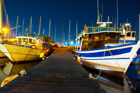 boats by a wooden pier in Alghero harbor, italyの写真素材