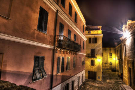 narrow street in Alghero old town by night, Italyの写真素材
