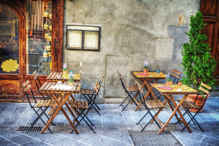 rustic tables and chairs by a trattoria in Florence, Italyの写真素材