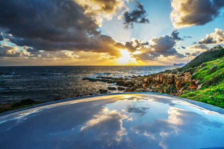 dark clouds reflected on a car rooftop at sunset