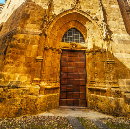 wooden door in Duomo steeple in Alghero, Italyの写真素材