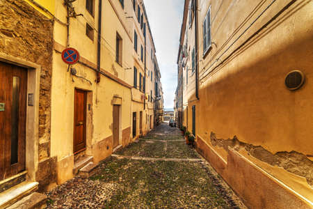 narrow street leading to the sea in Alghero, Italyの写真素材