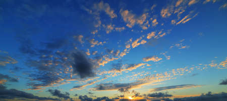 blue and orange sky with clouds at sunsetの写真素材
