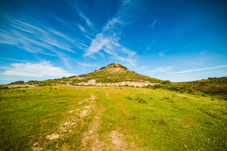 green hill under a blue sky in Sardinia, Italy