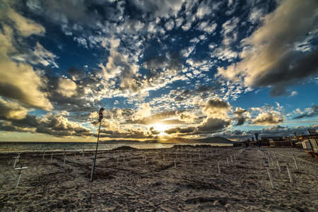 dramatic sky over the beach at sunset in Sardinia, Italyの写真素材