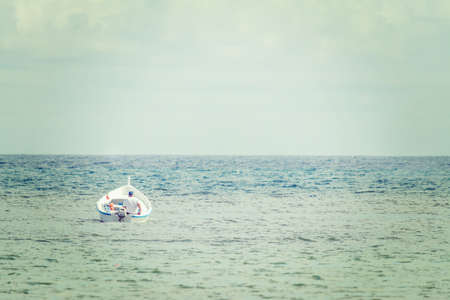 old man in a small boat alone in the seaの写真素材