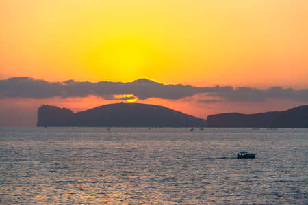 boat by Capo Caccia at sunset, Sardiniaの写真素材