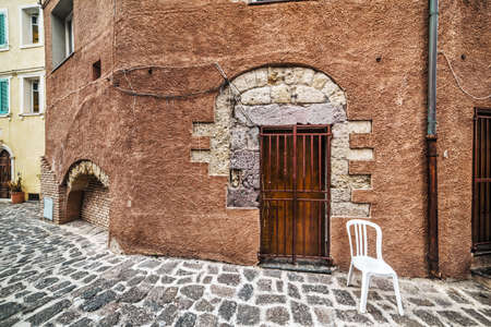 plastic chair in a rustic corner in Castelsardo, Sardiniaの写真素材