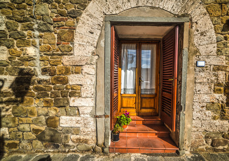 door in a rustic facade in Tuscany, Italyの写真素材