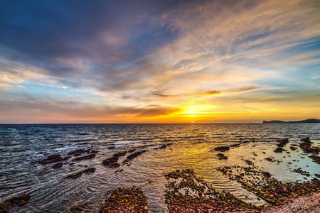 Colorful sky over Alghero shroeline at sunset, Sardinia