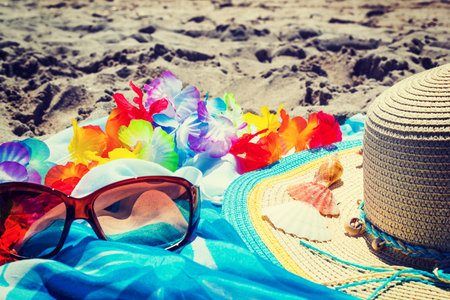 sunglasses and straw hat on the sandの写真素材