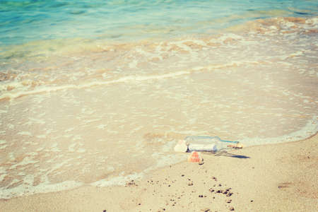 Bottle with message on the foreshore of a tropical islandの写真素材