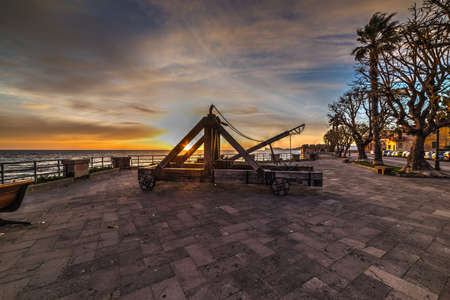 Antique catapult on a colorful sunset in Alghero. Sardinia, Italyの写真素材
