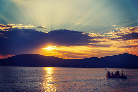 Dark clouds and shining sun at sunset.