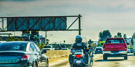 Police officer on motorcycle in 405 freeway in Los Angeles, Californiaの写真素材