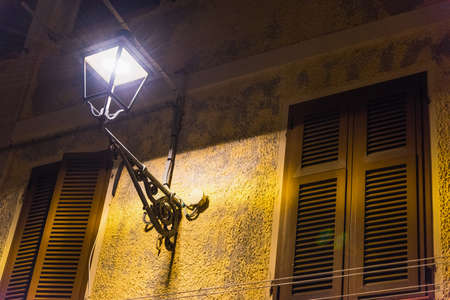 Lamp post in old town Alghero at night, Sardiniaの写真素材