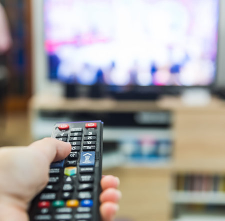 Woman holds a remote control while watching tv