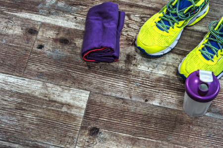 Running shoes, towel and water bottle on the floorの写真素材