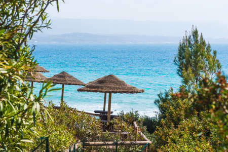 Straw parasols by the sea in Le Bombarde beach, Alghero. Sardinia, Italyの写真素材