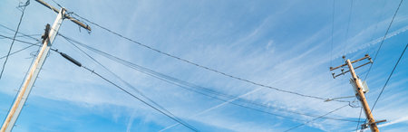 High voltage cables under a cloudy sky