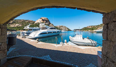 Luxury yachts seen from an arch in Poltu Quatu. Sardinia, Italyの写真素材