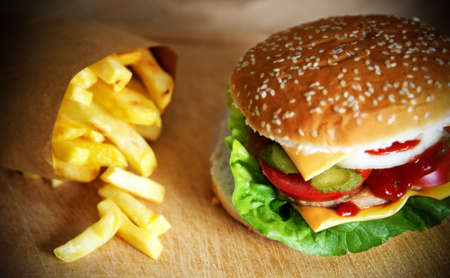 Close up of a hamburger sandwich and french fries on a wooden tableの写真素材