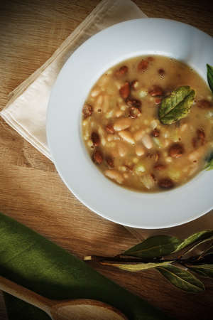 Beans and fregola soup on rustic wooden tableの写真素材